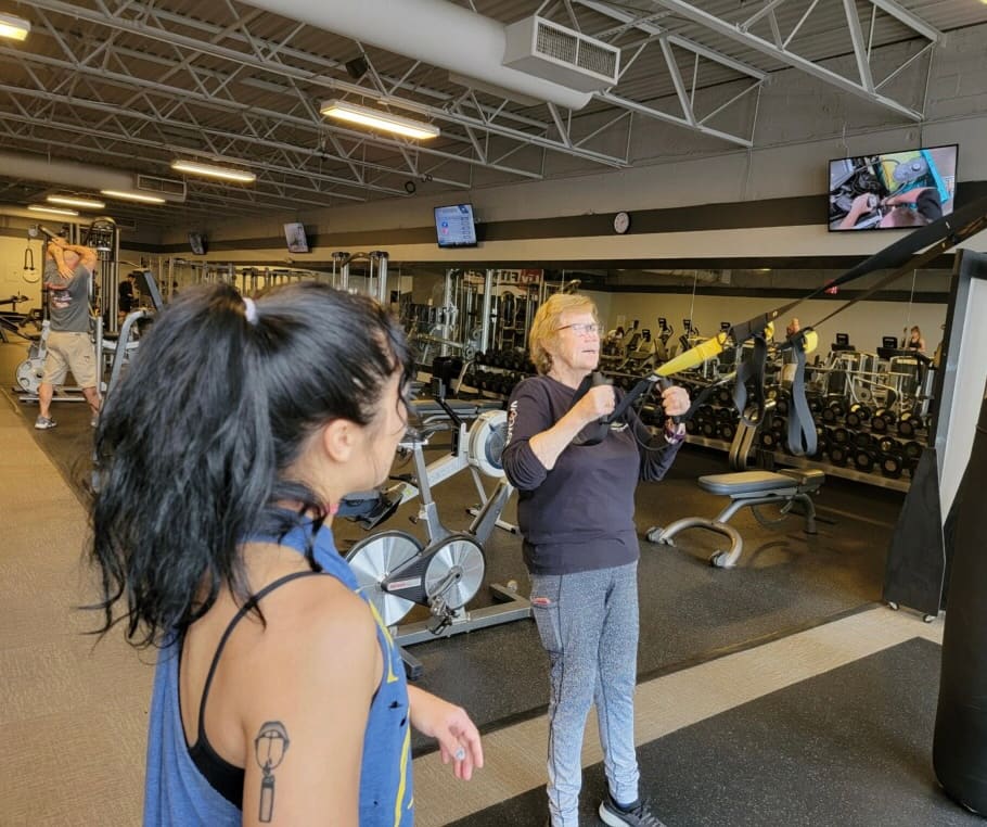 Trainer coaching a member on the gym floor
